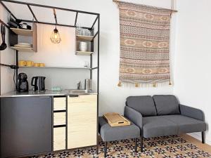 a living room with a chair and a table at Yellow Flamingo Studio Fuseta in Fuzeta
