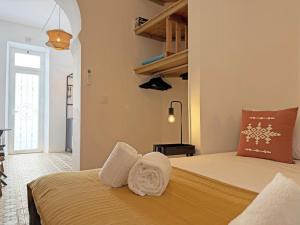 a bedroom with a bed with towels on it at Yellow Flamingo Studio Fuseta in Fuzeta
