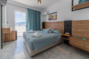 a bedroom with a bed with two towels on it at Haraki Bay Hotel and Luxury Apartments in Haraki