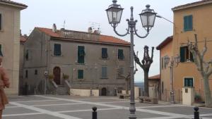 een straatlicht in het midden van een straat met gebouwen bij Abitare il Borgo Piazza del Popolo in Castagneto Carducci