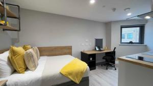 a bedroom with a bed with yellow pillows and a desk at The Coal Yard in York +6 photos