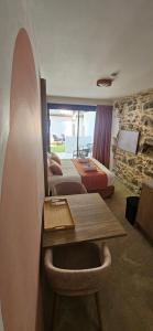 a hotel room with a bed and a table and a room at Villa Onyra - Studios, Suites & Villa in Saint-Cyr-sur-Mer