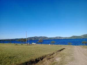 a dirt road next to a large body of water at Los Colibríes de Potrero in Potrero de Garay