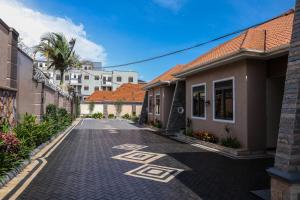 an empty street with houses and a palm tree at Ruts Golden Homes in Kampala