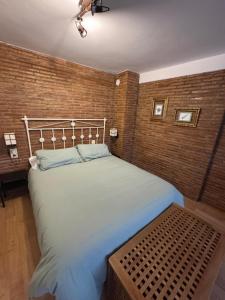 a large bed in a room with a brick wall at Alcalá Zona Centro Duplex in Alcalá la Real