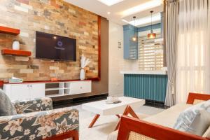 a living room with a tv on a brick wall at Ruts Golden Homes in Kampala