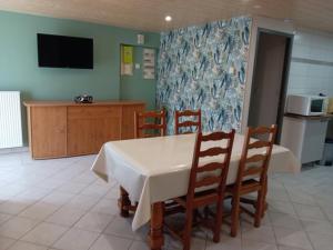 a dining room with a table and chairs and a tv at Gite du neufbourg in Courtils +3 photos