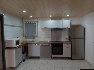 a kitchen with a refrigerator and a microwave at Gite du neufbourg in Courtils