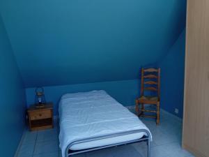 a blue room with a bed and a wooden chair at Gite du neufbourg in Courtils