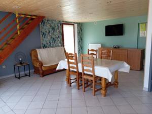 a living room with a table and chairs and a couch at Gite du neufbourg in Courtils