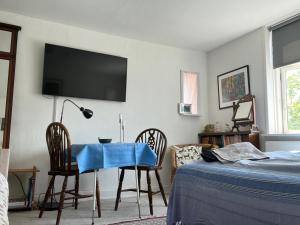 a bedroom with a table and chairs and a tv on the wall at Friisenborg in Jelling