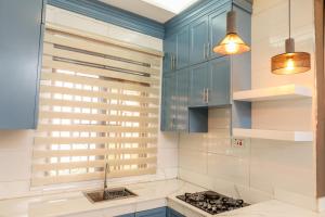 a kitchen with blue cabinets and a stove at Ruts Golden Homes in Kampala
