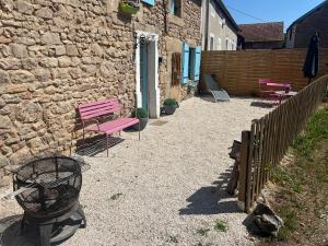 a patio with a pink bench and a fence at La Petite Maison - 4 voyageurs in Voudenay-lʼEglise