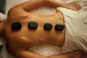 a woman laying on a bed with black pads on her back at Pereh Mountain Resort in Gadot +48 photos