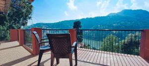 a chair on a balcony with a view of the mountains at The Lake BnB in Nainital