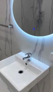 a bathroom with a white sink and a mirror at Aura Stay Apartment in Tirana