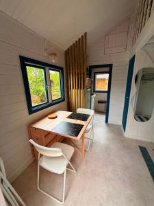 a room with a table and chairs in a tiny house at La Cabane du Pti' Bonheur in Saint-Coulomb