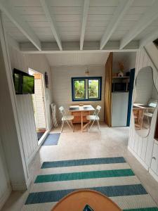 a room with a table and chairs in a house at La Cabane du Pti' Bonheur in Saint-Coulomb
