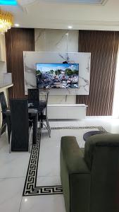 a living room with a tv hanging on a wall at Cité La Vie in Douala +2 photos