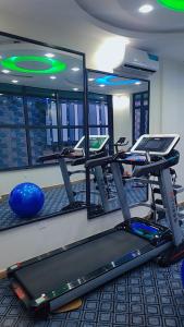 a gym with several treadmills and a mirror at Cité La Vie in Douala
