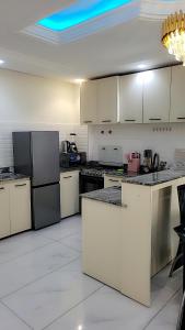 a large kitchen with white cabinets and appliances at Cité La Vie in Douala