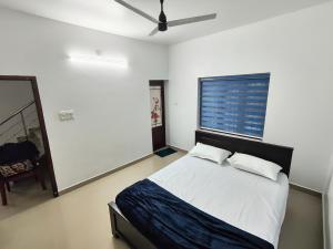 a bedroom with a bed with two pillows and a window at Future homes in Kunnamkulam