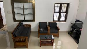 a living room with a couch and chairs and a mirror at Future homes in Kunnamkulam