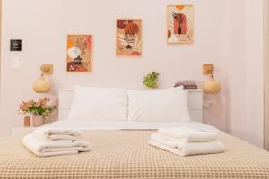 a bedroom with a bed with towels on it at Almond Jacuzzi Suites - Private Indoor Jacuzzi - Self Check-In - Free & Easy Street Parking in Thessaloniki