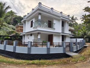 a white house with a balcony in front of it at Future homes in Kunnamkulam