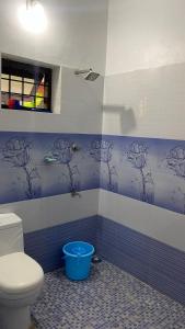 a bathroom with a toilet and a blue wall at Future homes in Kunnamkulam