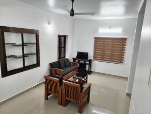 a living room with a chair and a mirror at Future homes in Kunnamkulam +9 photos