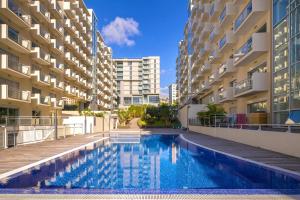 a swimming pool in the middle of two apartment buildings at Vista Mar Concórdia by Rentallido in Funchal