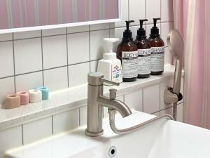 a bathroom sink with a faucet and some bottles of soap at stay mongle in Suwon +43 photos