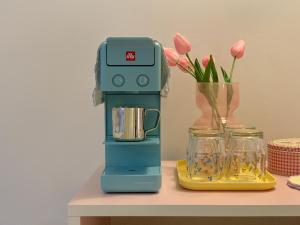 a blender sitting on a table next to a vase of flowers at stay mongle in Suwon