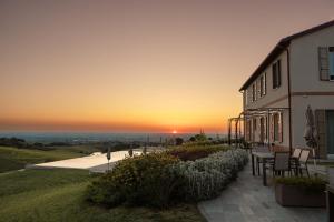 a house with the sunset in the background at Podere Mantignano 2 in Faenza
