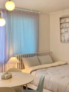 a bedroom with a bed and a table and chairs at stay mongle in Suwon