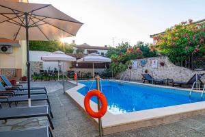a swimming pool with an umbrella and a red ring in it at Oscar in Kallithea Halkidikis