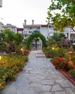 a stone walkway with flowers in front of a building at Oscar in Kallithea Halkidikis