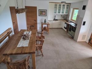 a kitchen and dining room with a wooden table and chairs at Pirman Vineyard Cottage in Bučka +6 photos