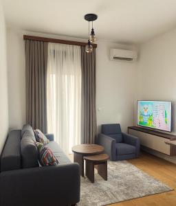 a living room with a couch and a table and a tv at BIJELA apartman 2025 in Bijela
