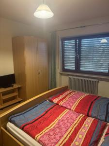 a bedroom with a bed with a colorful blanket at Sempre Bello in Iffezheim