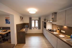 a kitchen with a counter and a table in it at Appartement Neumayer in Viehhofen