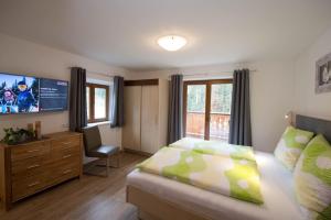 a bedroom with a bed and a desk and a television at Appartement Neumayer in Viehhofen