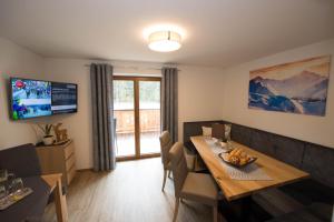 a living room with a dining room table and a television at Appartement Neumayer in Viehhofen +29 photos