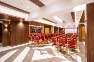 a conference room with red chairs and wooden panels at Treebo Premium Merrit in Katrab