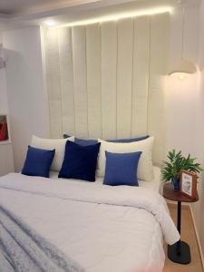 a large white bed with blue pillows in a room at Smart Home near beach and pool in Sharm El Sheikh +21 photos