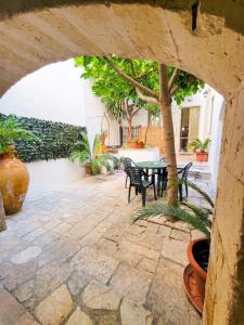 a patio with a table and chairs and a tree at Mercanti in Manduria