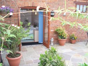 a cat sitting in front of a door with plants at West View Farm in Louth