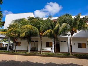 a group of palm trees in front of a building at Hotel Yaltas Inn in Tola