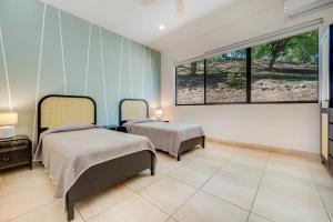 a bedroom with two beds and a large window at Casa Carmen in Potrero